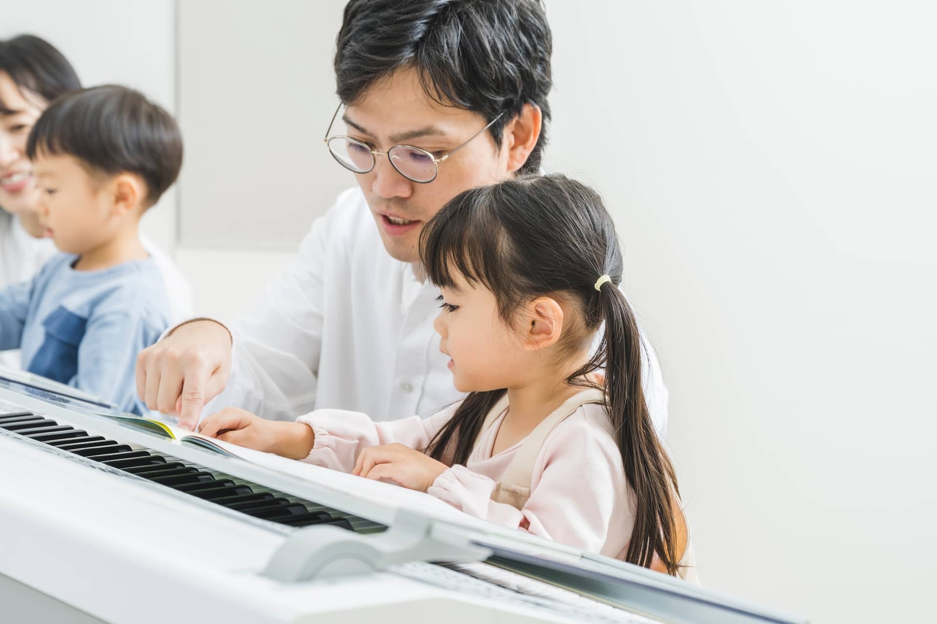 お父さんが子どもの音楽レッスンに寄り添う様子
